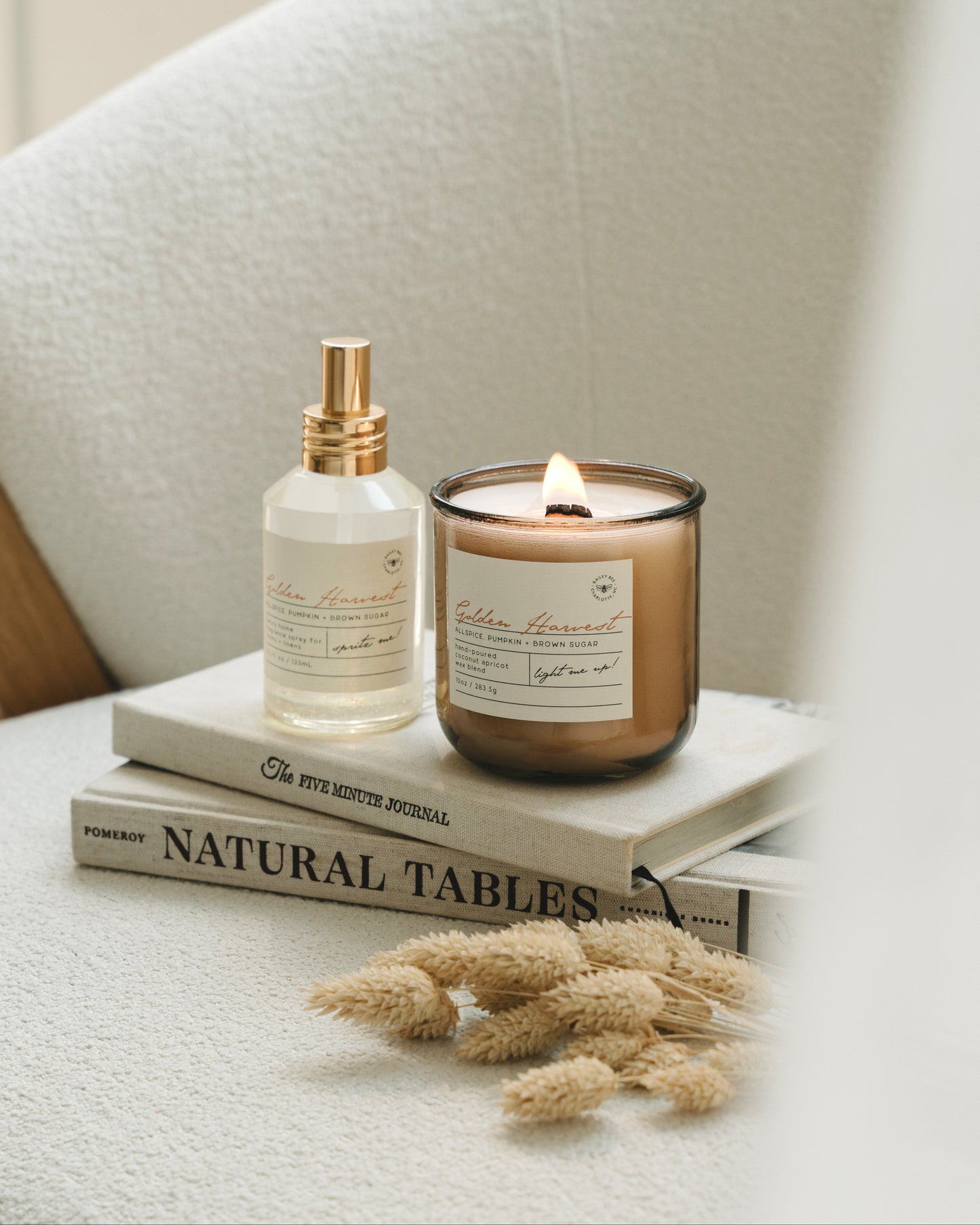 Candle and bottle on books with a neutral background