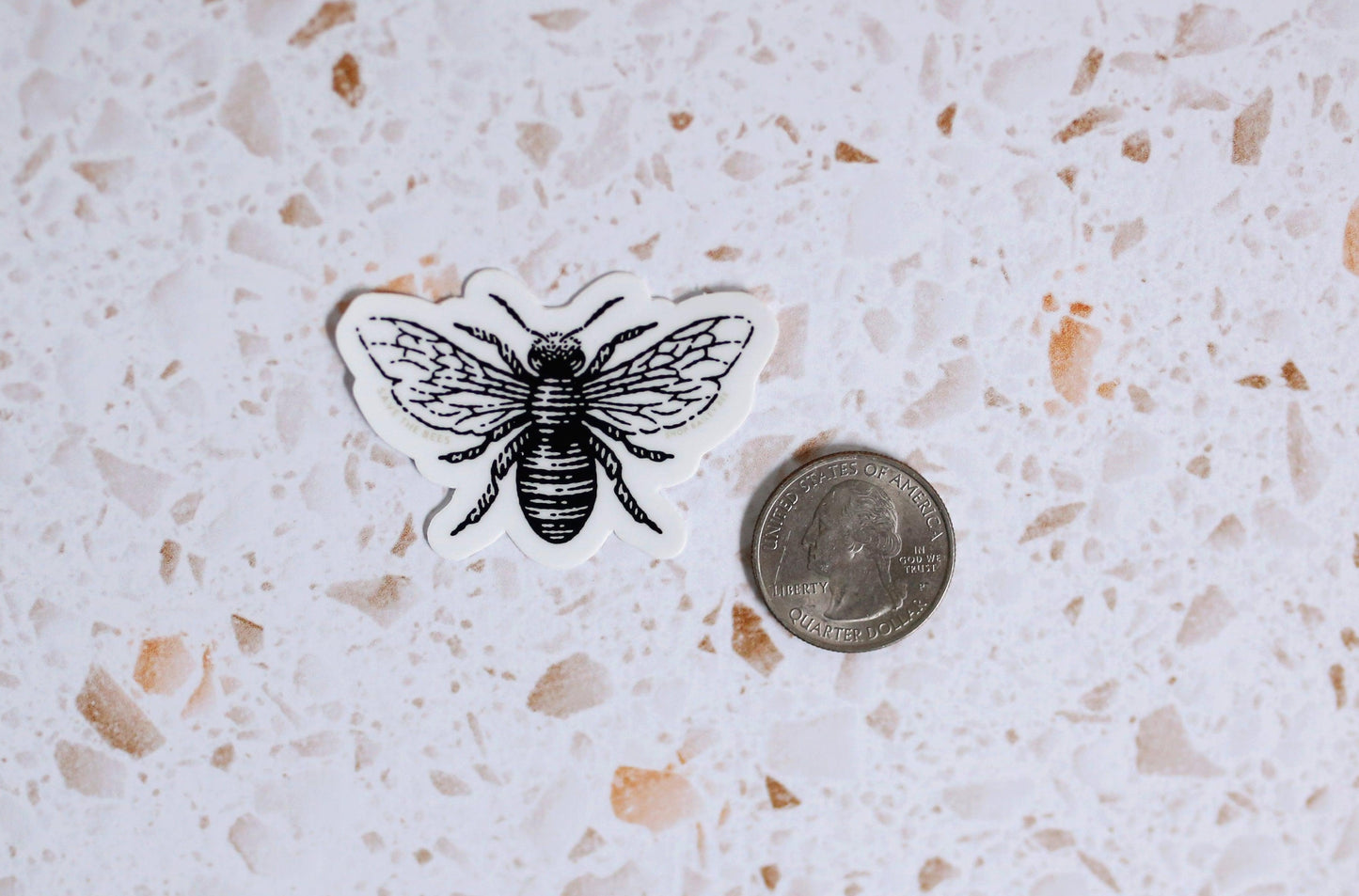 save the bees sticker next to a quarter for size comparison