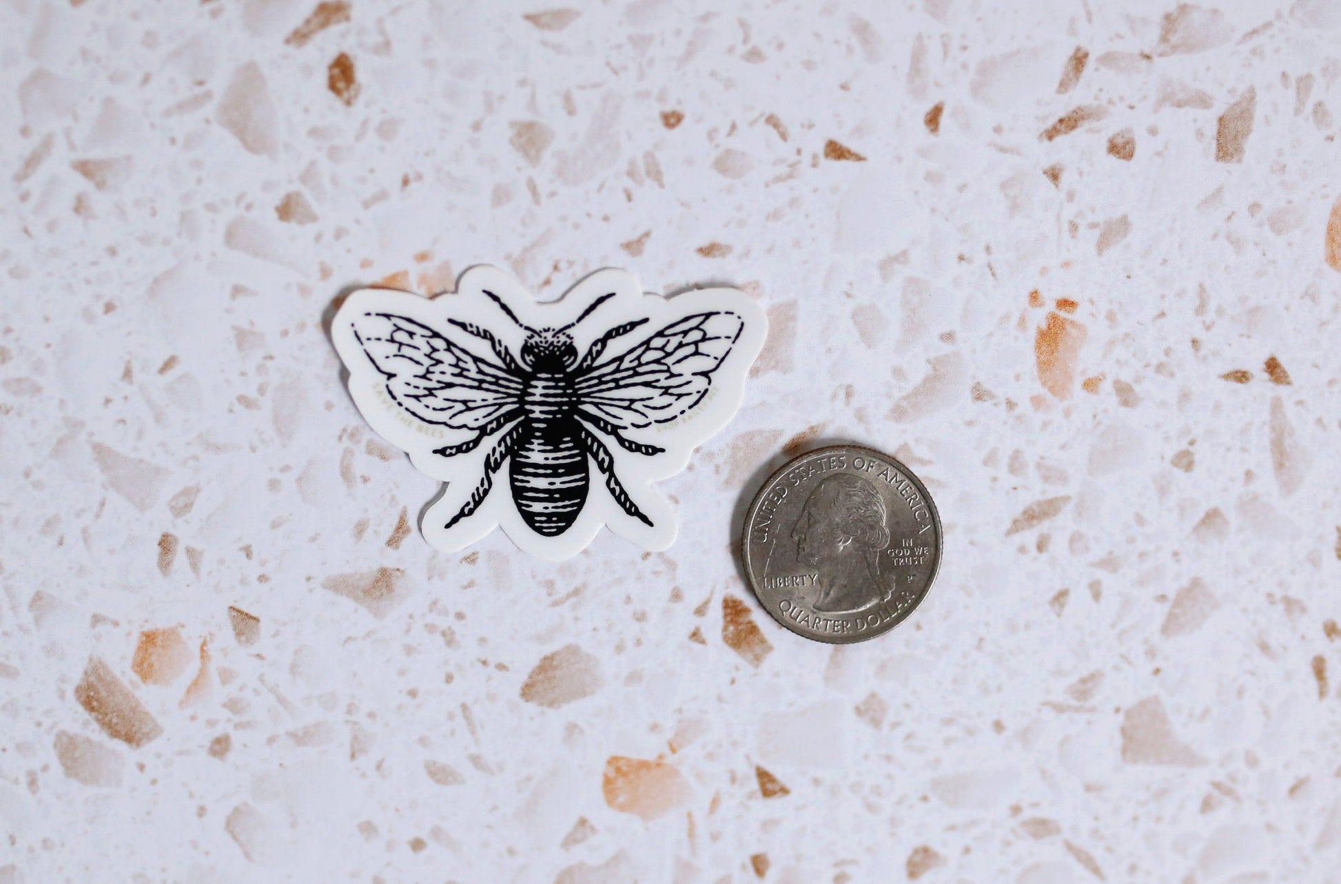 save the bees sticker next to a quarter for size comparison
