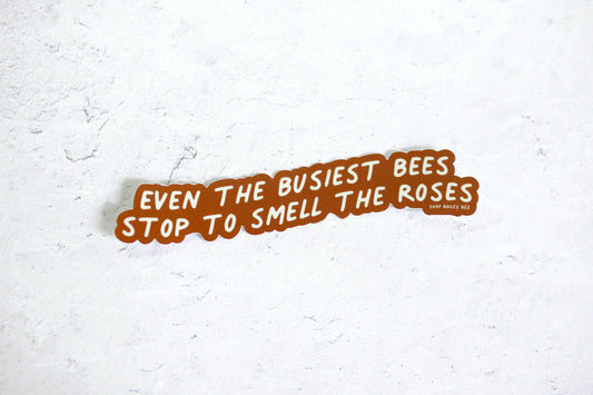 even the busiest bees stop to smell the roses sticker on grey backdrop